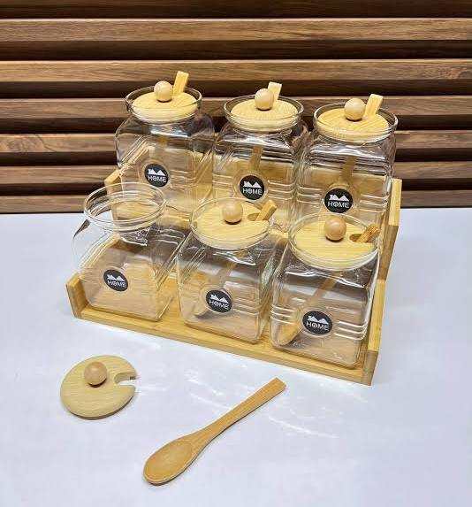 Ensemble de 6 bocaux en verre transparent, avec couvercles et cuillères en bambou, présentés sur un support assorti.